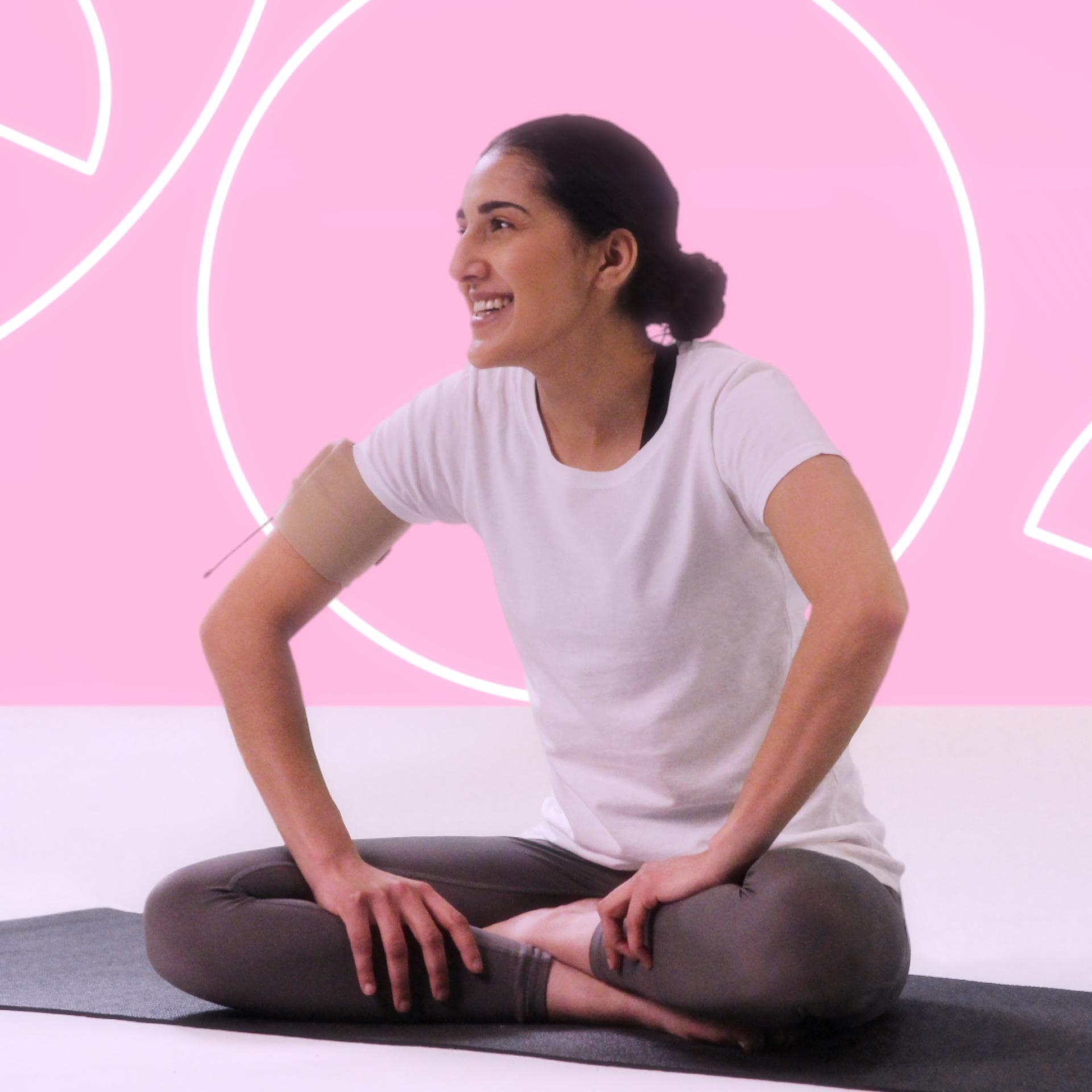 A woman smiling and looking away from the camera with her legs crossed