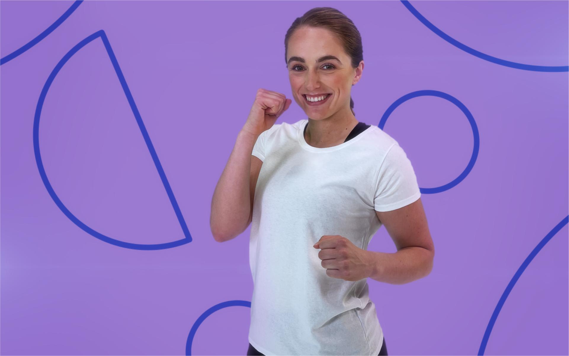 A woman in a fighting pose, smiling looking to camera