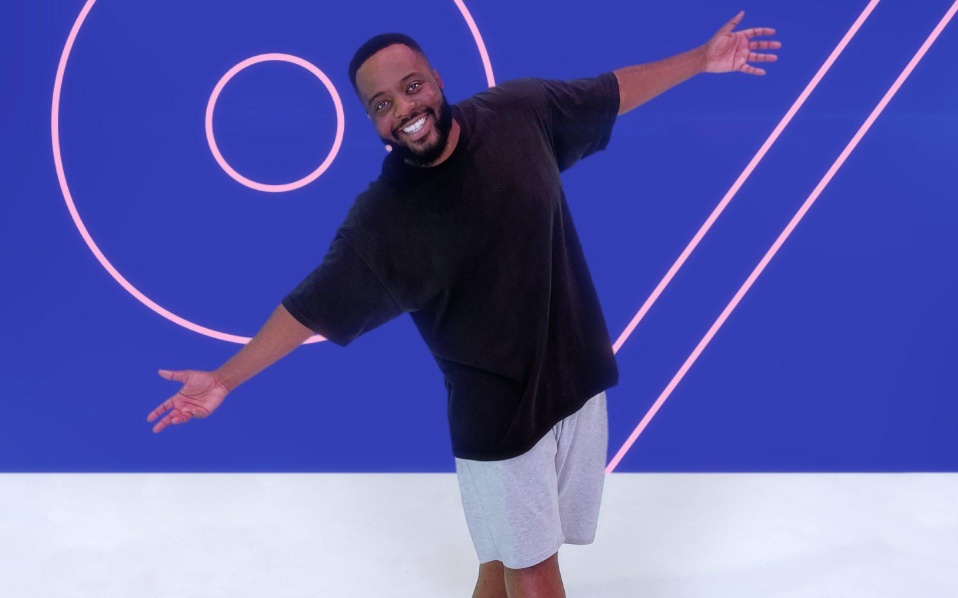 A man smiling to camera with his arms outstretched